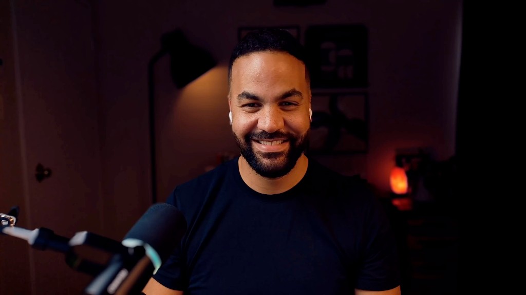 Tyler White smiling at his desk with a microphone setup